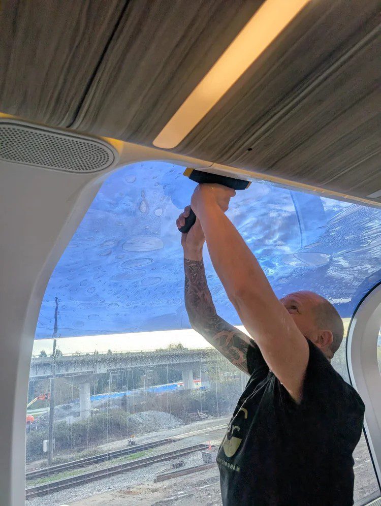 Window film installation inside a Rocky Mountaineer dome railcar