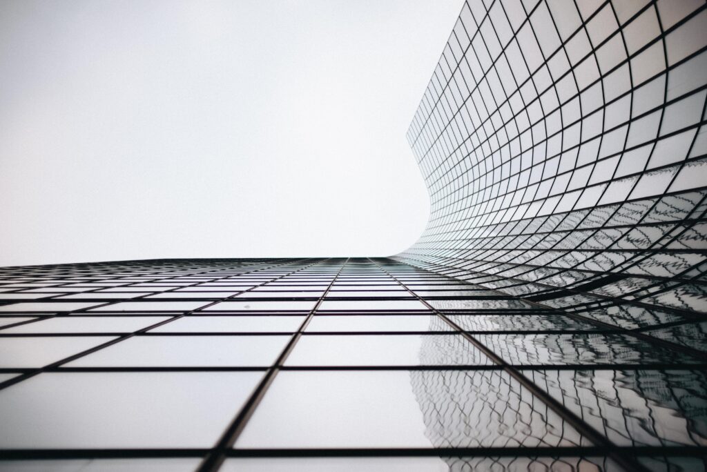 Reflective glass windows on a modern commercial building demonstrating the one-way glass light differential effect