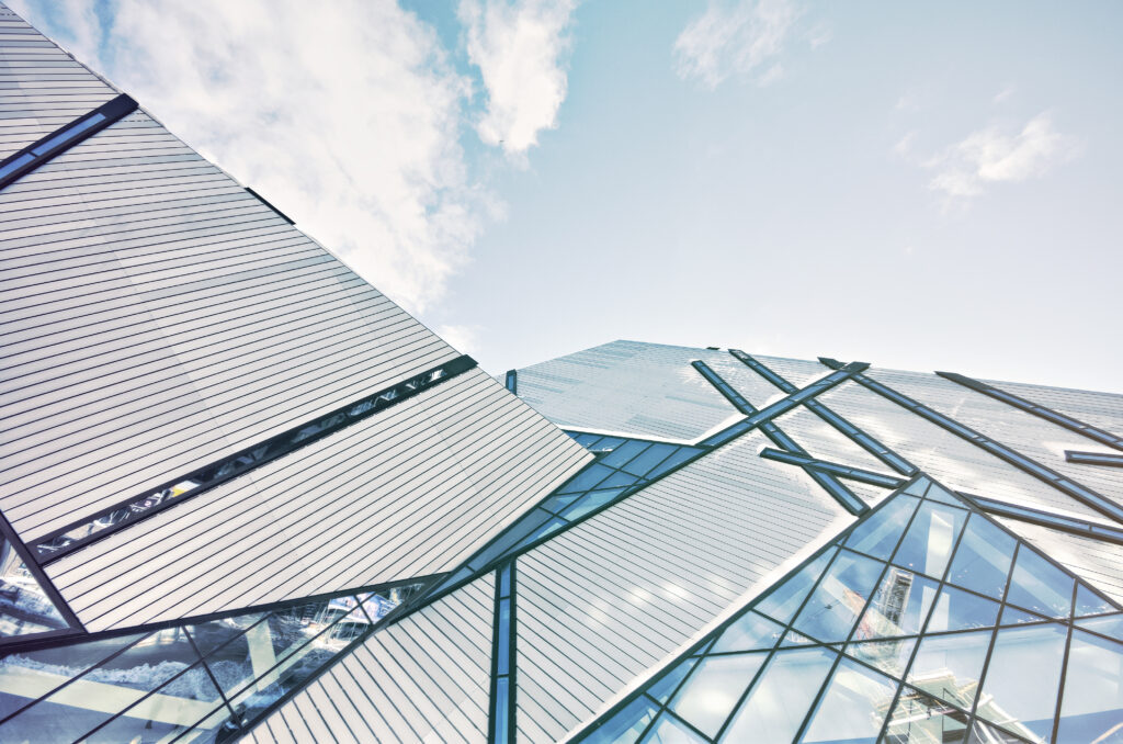 Modern glass and steel building facade - commercial high-rise glass curtain wall requiring bird safe window film