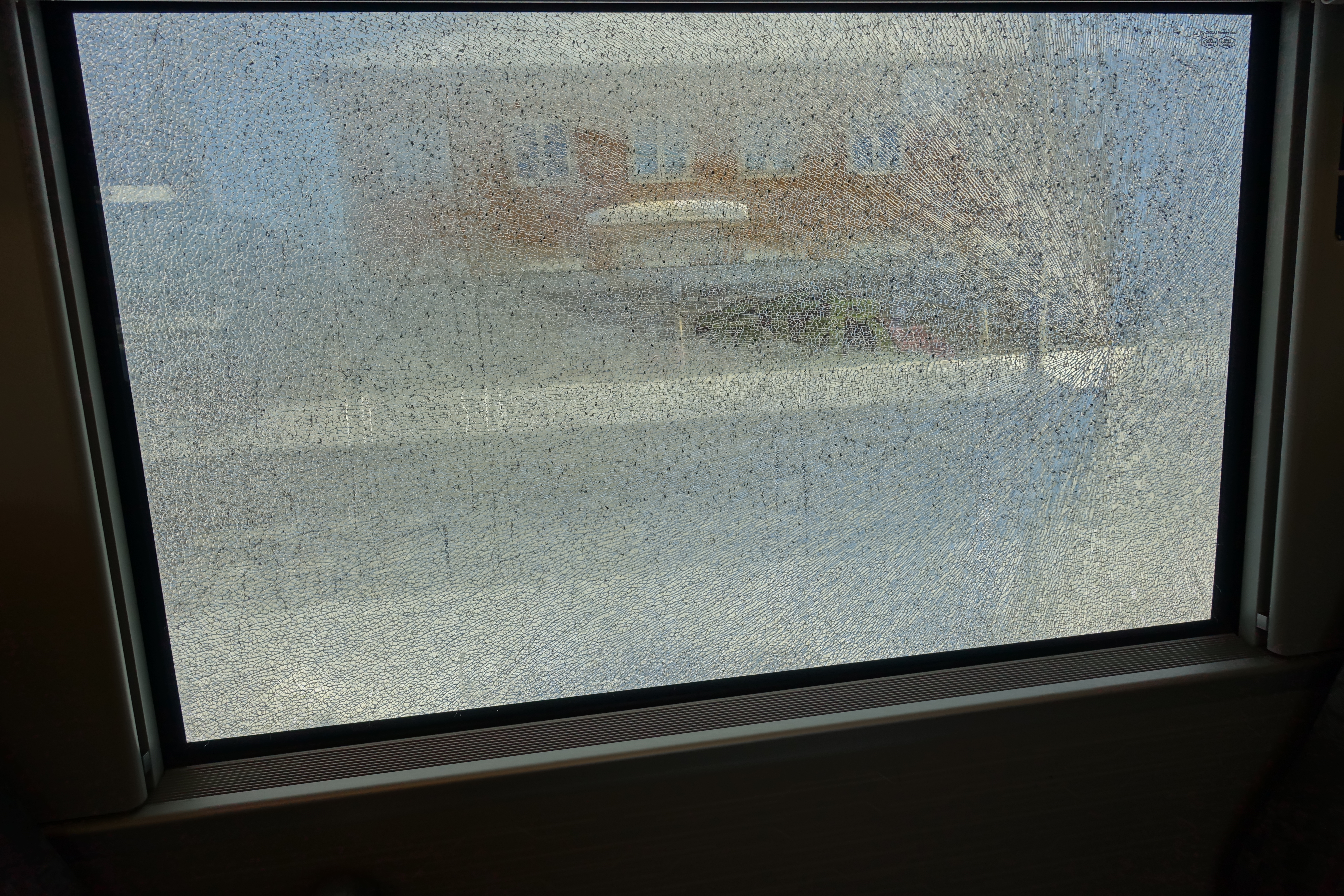 Laminated safety glass holding fragments after impact, similar to security window film behavior