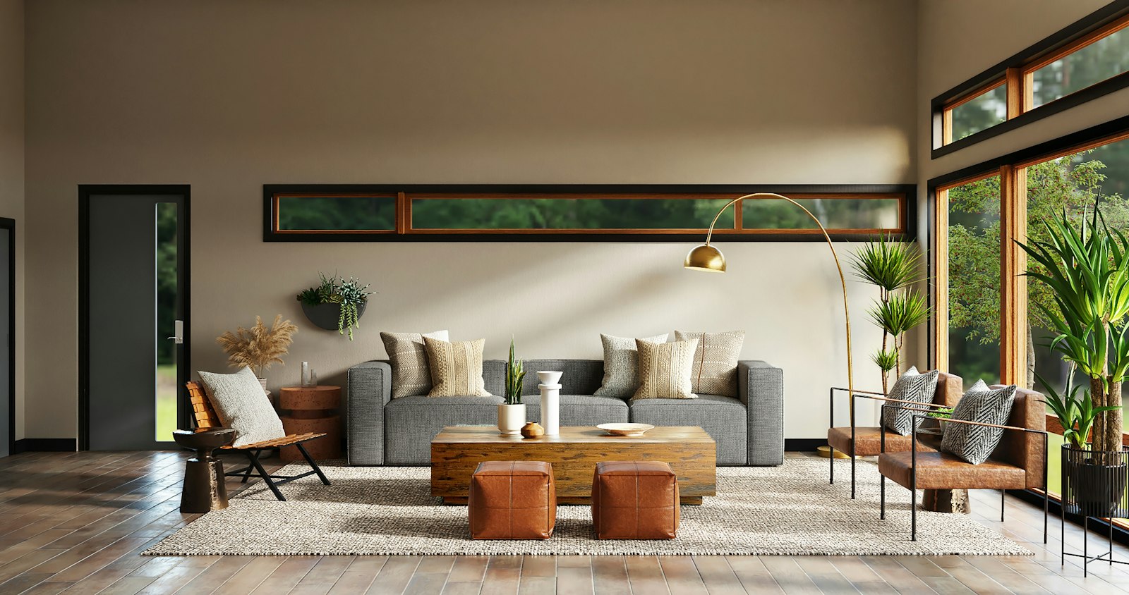 Modern grey sofa and armchairs in a bright room with floor-to-ceiling windows and direct sun