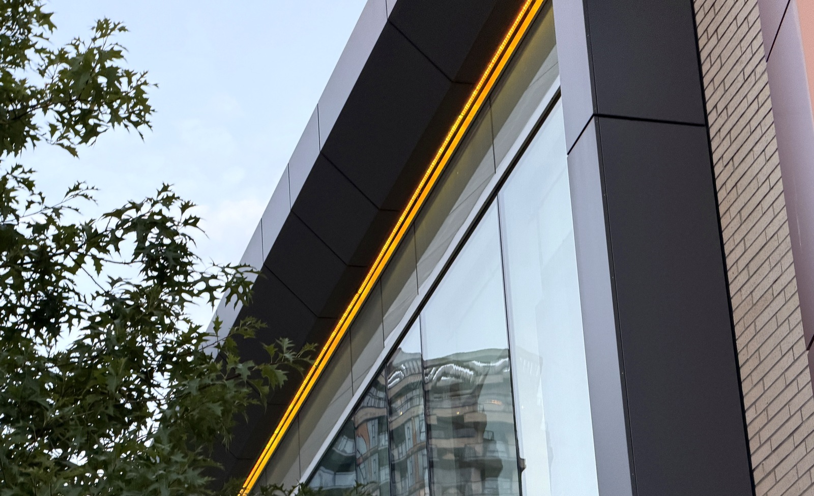 Site-visit view looking upward along the community centre glass facade.